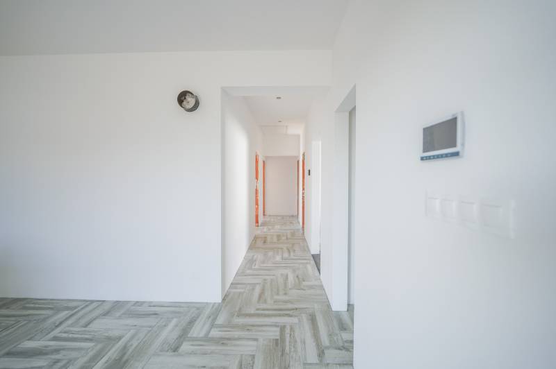 A hallway in a family house with wooden flooring and white walls.