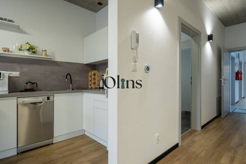 A kitchen unit in offices with modern appliances and wooden flooring.