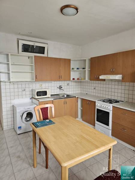 Kitchen in a 2-room apartment with a kitchenette, dining table, and appliances.