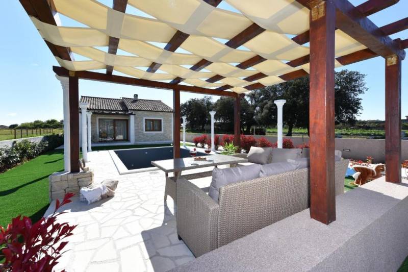 The garden of a family house in Bibinje with a gazebo and a pool on the terrace.