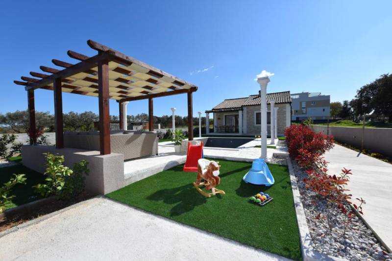 A family house in Bibinje with a gazebo, swimming pool, and lawn playground.