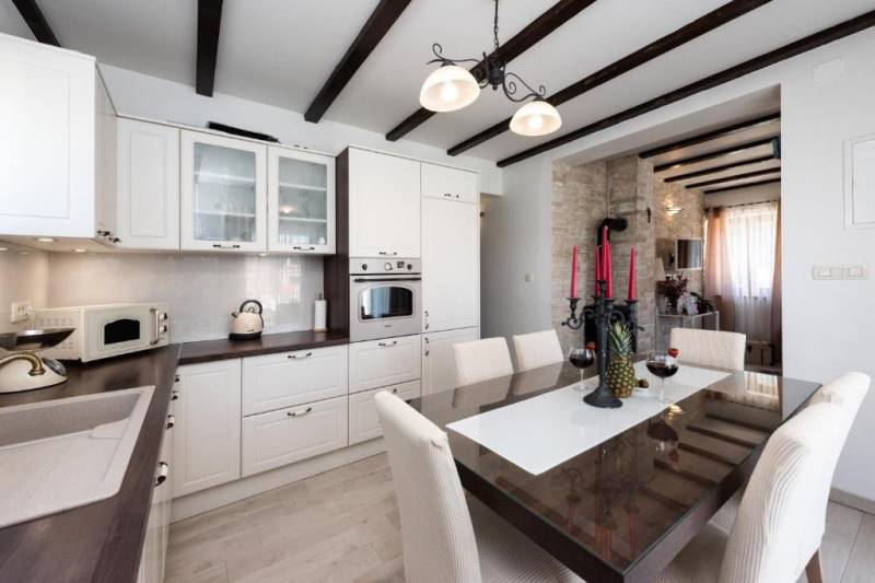 Dining room in a family house with a wooden ceiling and an elegant table.
