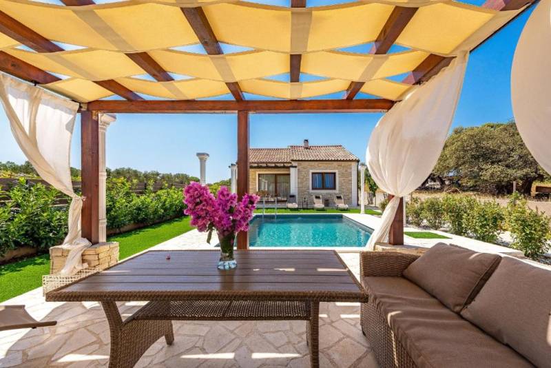 A family house in Bibinje with a gazebo, a pool, and a beautiful garden seating area.