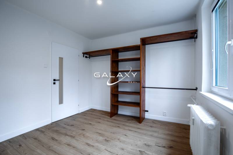 A room on Boriny Street in a 3-room apartment with wooden flooring and shelves.