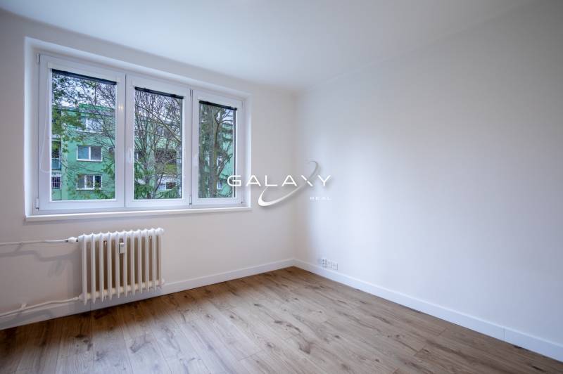 An empty room with a wooden floor and a window in a 3-room apartment on Boriny Street.