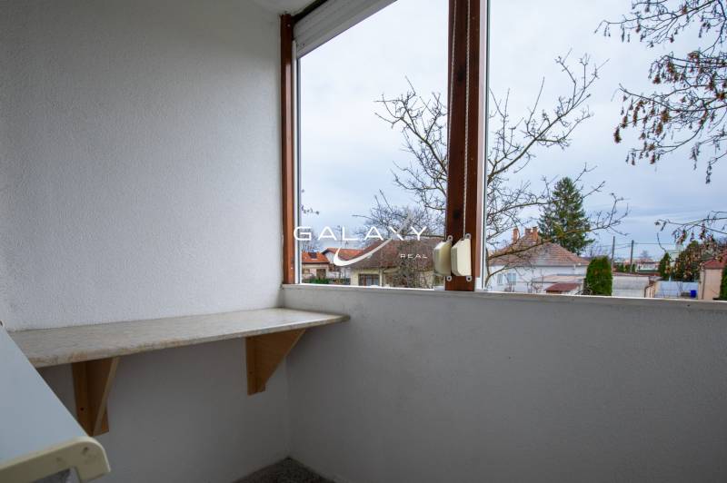 Renovated balcony in a 3-room apartment on Boriny Street with a view of the trees.