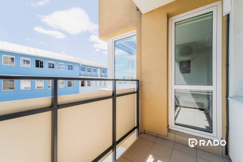A balcony with a view of a blue building in a 2-room apartment in Trenčín.