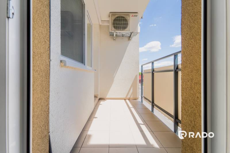 Balcony of a 2-room apartment in Trenčín with a view of the sunny blue sky.