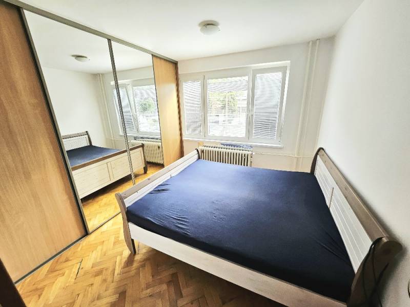 Bedroom in a 3-room apartment with wooden flooring, a large wardrobe, and a bed.