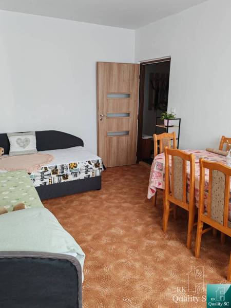 Living room in a 3-room apartment with a dining table and sofas.