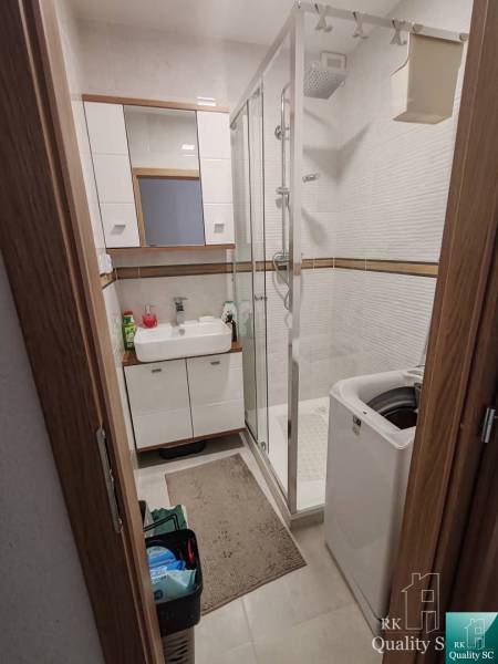 Bathroom in a 3-room apartment with a shower, sink, and washing machine.