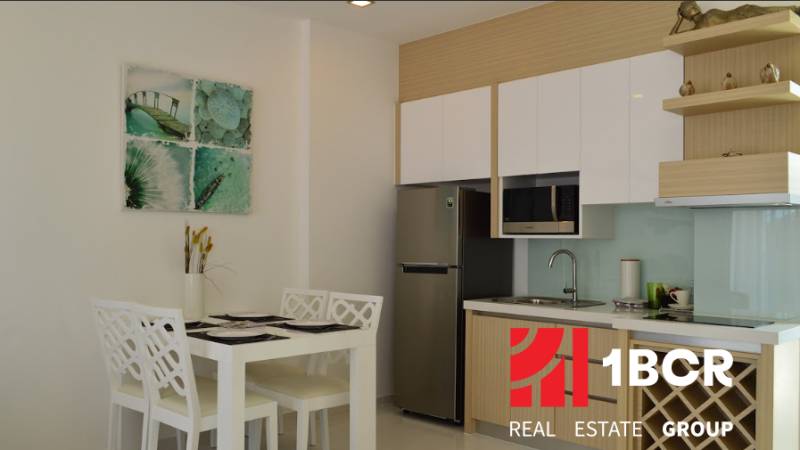 Kitchen and dining area in a 2-room apartment with four chairs and decoration.