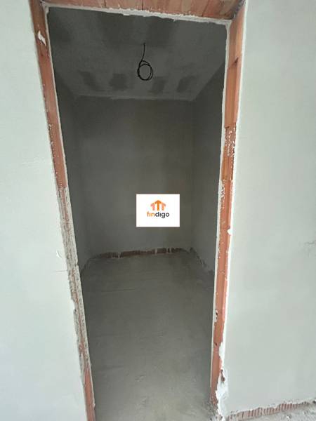 An empty room under construction in a family house with bare plaster walls.
