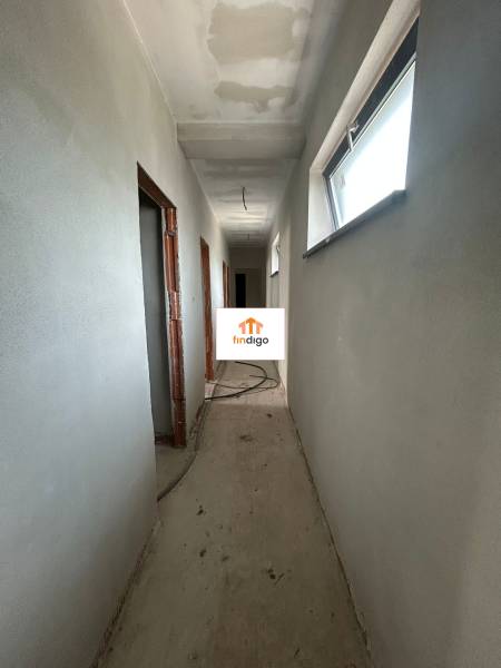 A hallway inside a family house with gray walls and narrow windows.