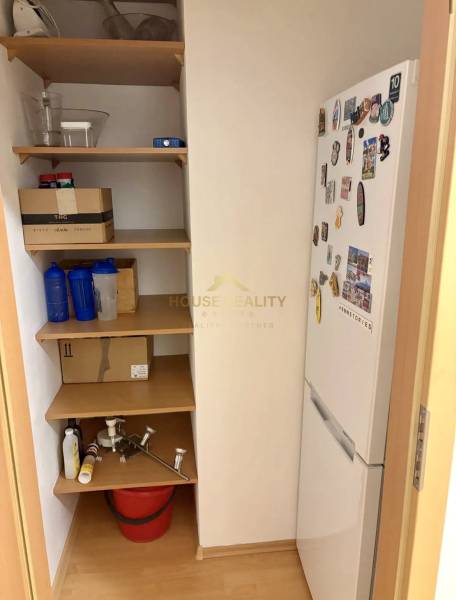 Storage space with shelves and a refrigerator in a 2-room apartment.
