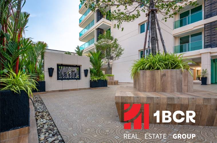 Construction of apartments in Pattaya with modern architecture and greenery around the buildings.