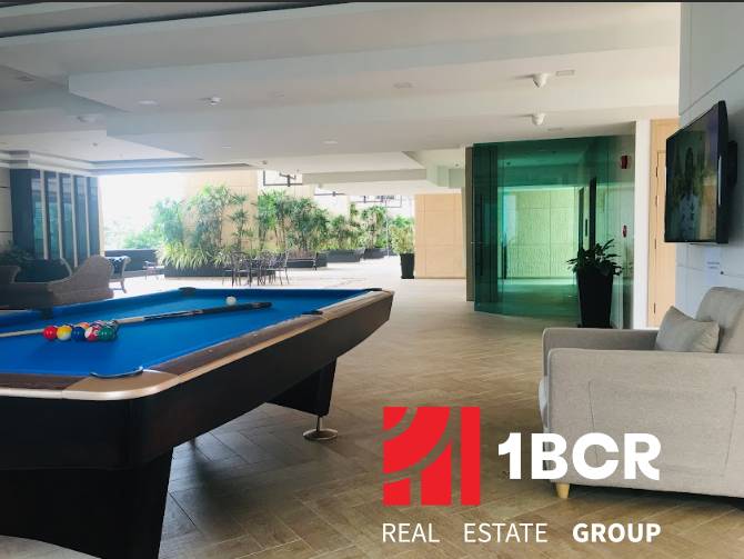 Interior space with a pool table and a sofa within the construction of apartments.