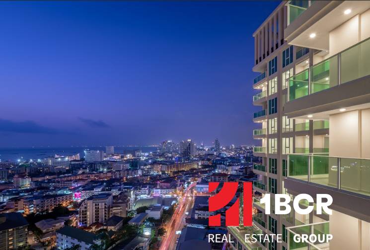 Night panorama of Pattaya with city lights and apartment construction in the foreground.