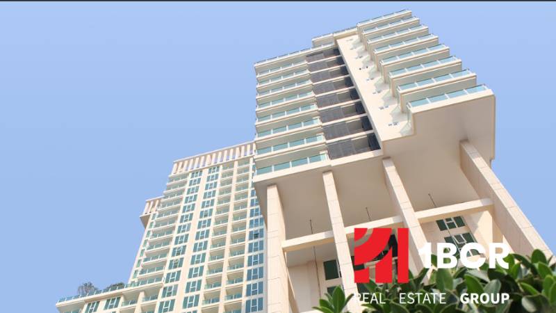 Apartment construction in Pattaya, a high-rise building with glass windows and balconies.