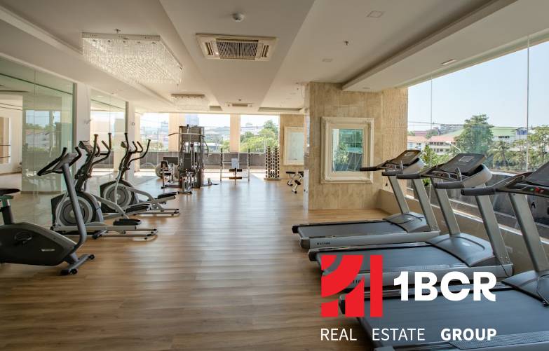 A gym with cardio equipment as part of the apartment construction.