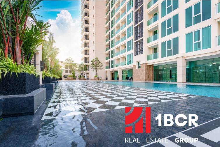 The construction of apartments in Pattaya includes a swimming pool, a high-rise building, and green plants.
