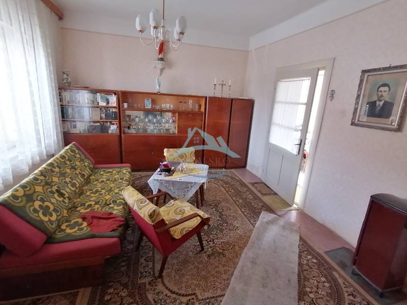 Living room in a family house with retro furniture and patterned carpets.