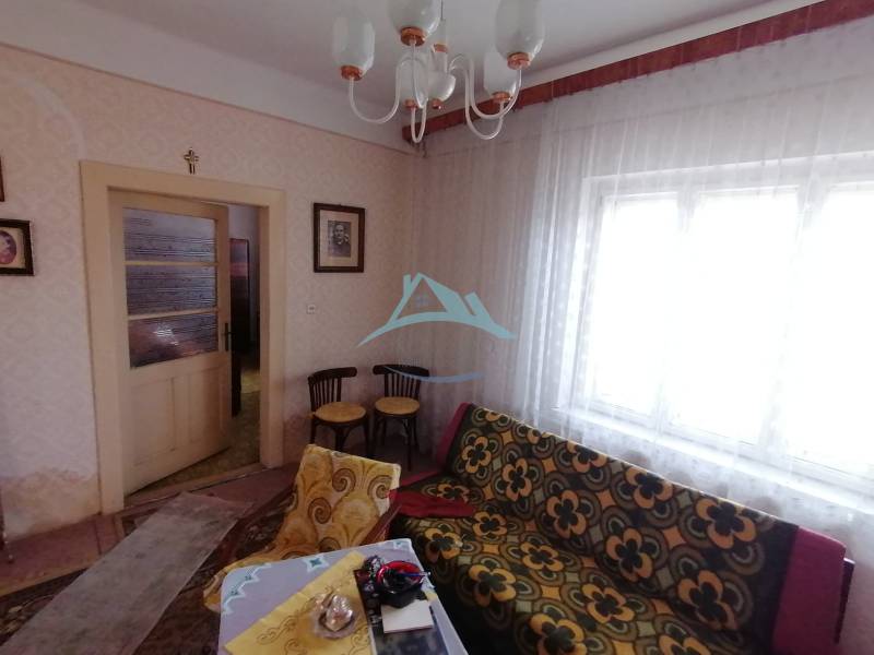 A room with a vintage sofa, furniture, and curtains in a family house.