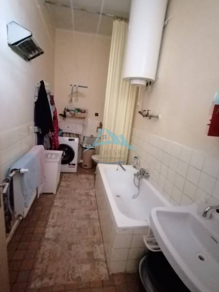 Bathroom in a family house with a bathtub, sink, and washing machine.