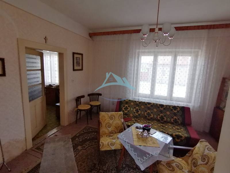Living room in a family house with retro furniture, patterned curtains, and soft lighting.
