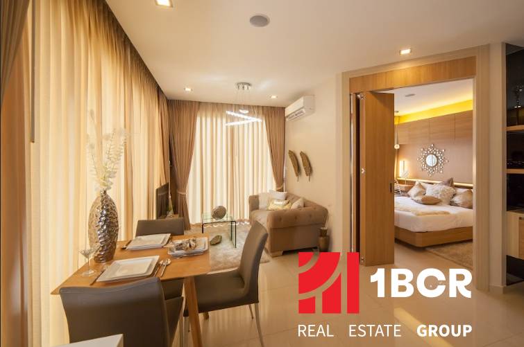 Living room and dining area with access to the bedroom in a 2-room apartment.