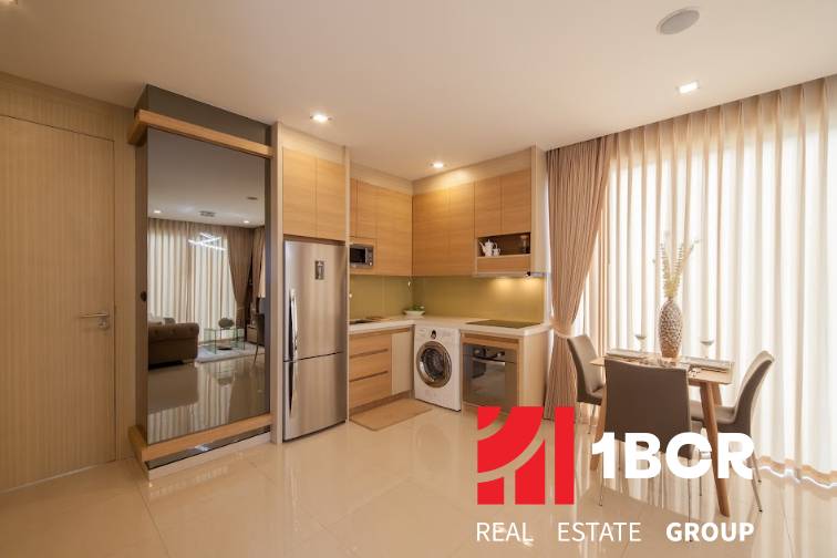 Kitchen corner in a 2-room apartment, with a dining table, refrigerator, and washing machine.