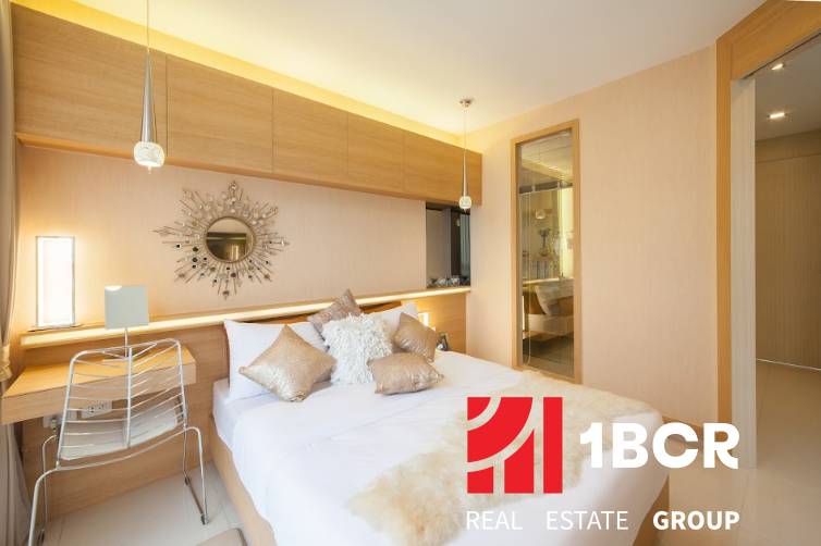 Bright bedroom in a 2-room apartment with a decorative mirror above the bed.