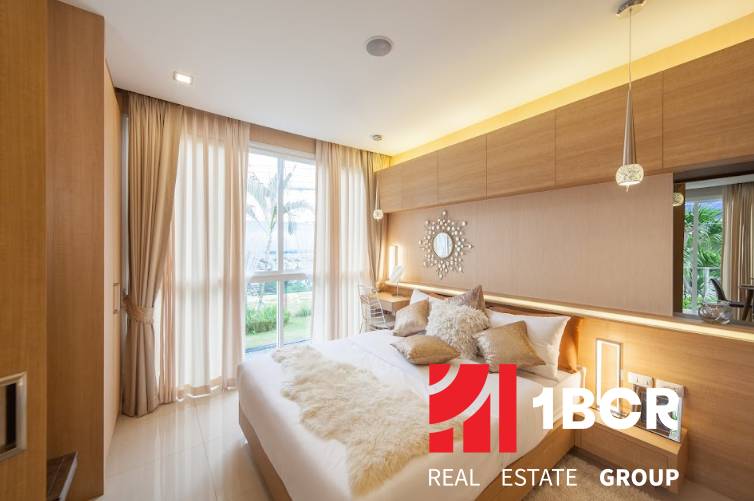 A bedroom in a 2-room apartment with modern furnishings and large windows letting in natural light.