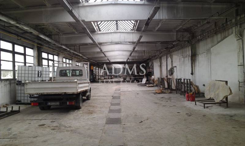 A spacious hall with a parked car and storage tanks in Levice.