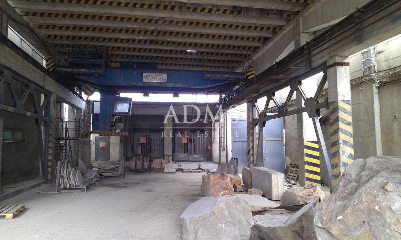 Industrial interior of warehouses and halls with large stone blocks and a crane.
