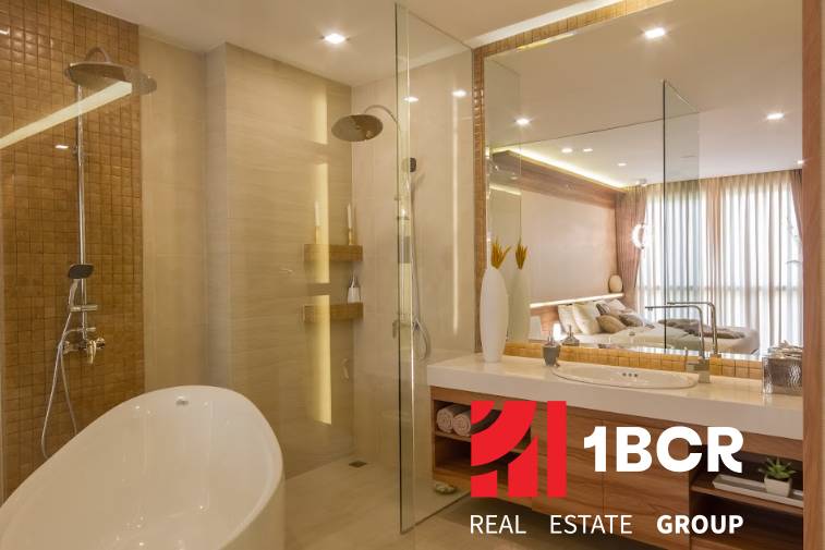 A bathroom in a 3-room apartment with a bathtub, shower, and a large mirror. Elegant lighting complements the space.