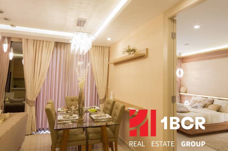 A softly lit dining room and living room with a set table in a 3-room apartment.