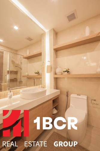 Bathroom of a 3-room apartment with a sink, mirror, and toilet.