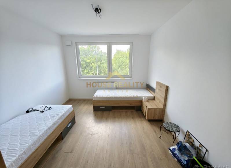 A room with two beds and a window, wooden floor in a 3-room apartment.