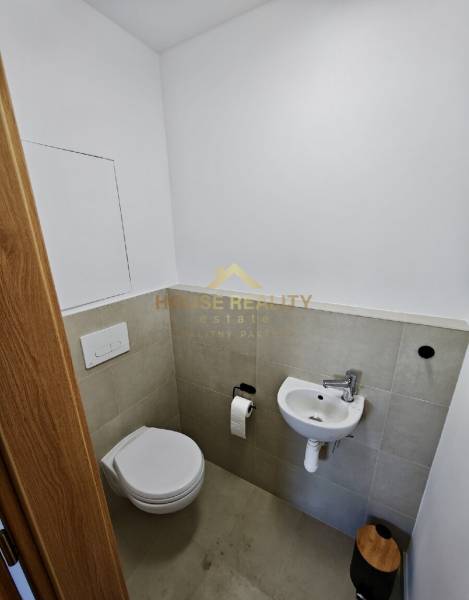 Bathroom with toilet, sink, and toilet paper holder in a 3-room apartment.