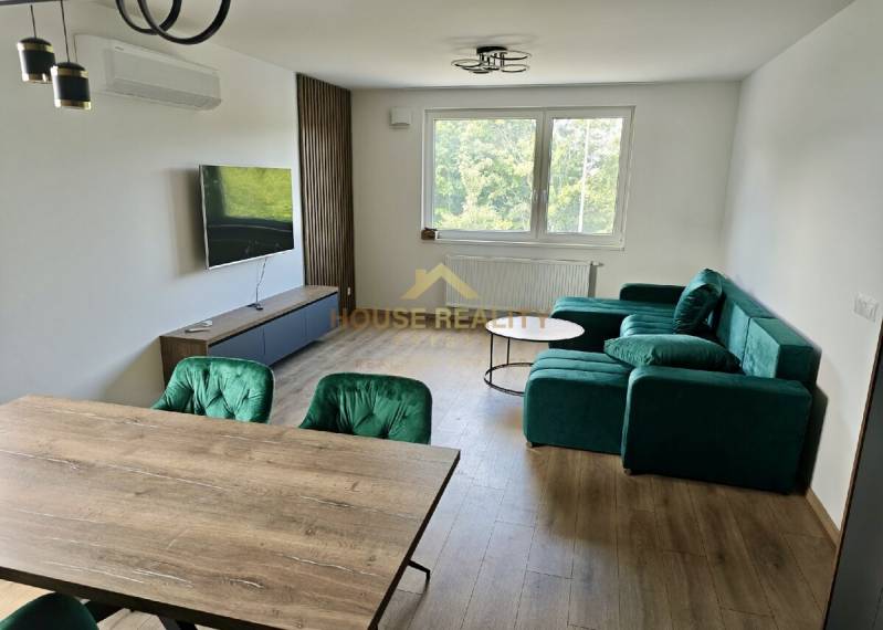 Living room in a 3-room apartment with a colorful sofa, dining table, and television.