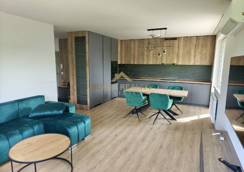 Living room in a 3-room apartment with wooden flooring and a green sofa.