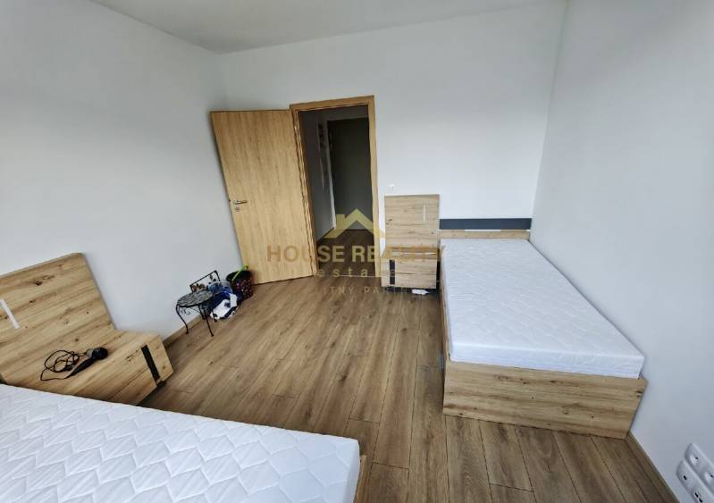 A bedroom with two single beds and wooden flooring, 3-room apartment.