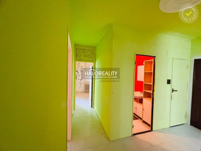 A corridor in a 3-room apartment with green walls and access to the rooms.