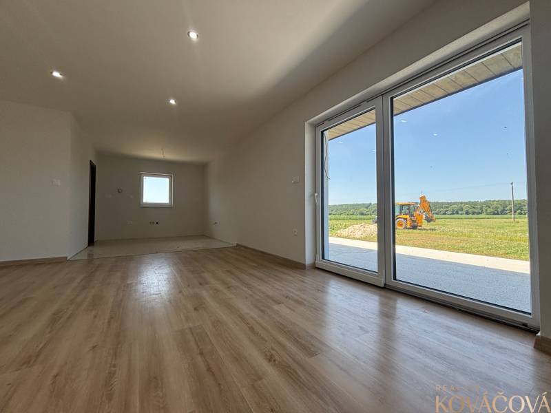 A spacious room with laminate flooring and large glass doors in a family house.
