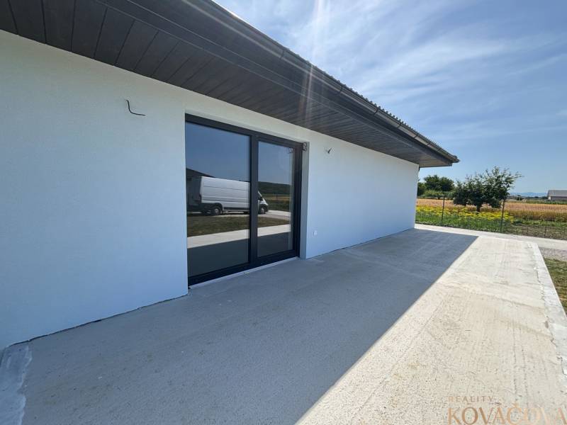A family house in Podlužany with a spacious terrace and large glass doors.