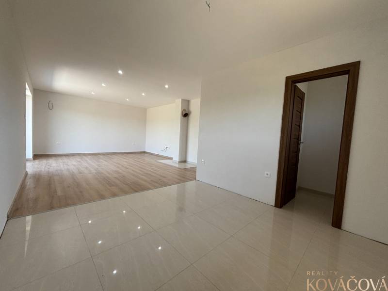 Interior of a family house with parquet and tiled flooring, wooden doors, white walls.