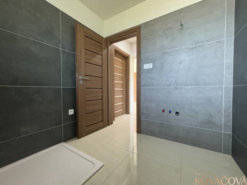 A bathroom in a family house with tiles, doors, and flooring in light shades.