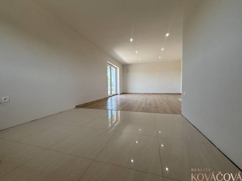 A spacious room in a family house with ceramic and wooden flooring.