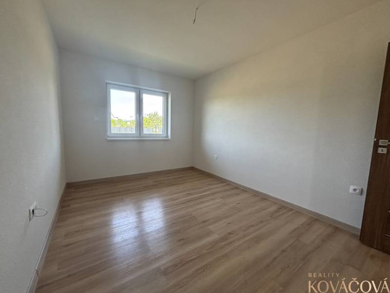An empty room with a wooden floor and a window in a family house.